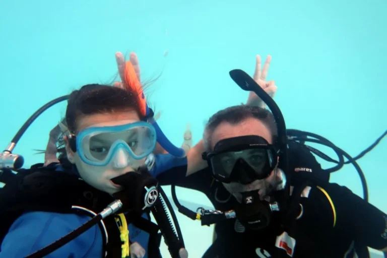 Instructor certificat de scufundări și un copil la curs Try Scuba, în piscină