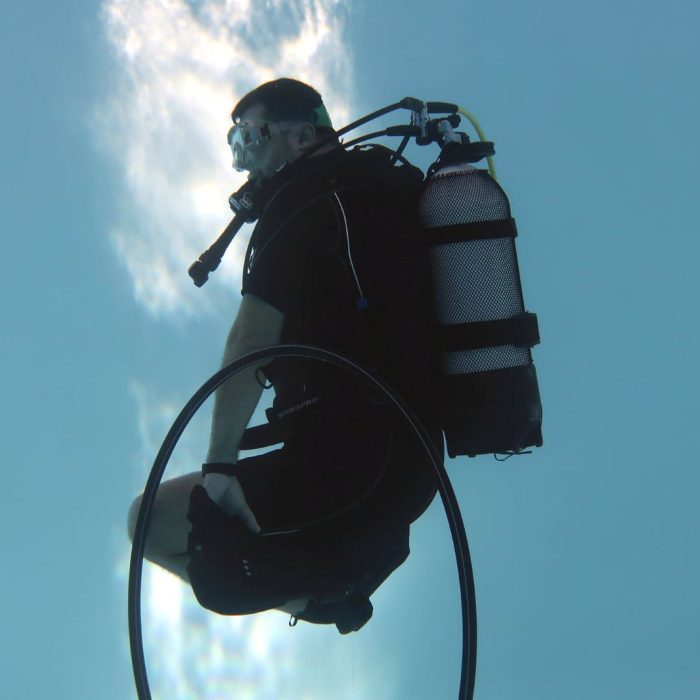 Cursant plutește controlat în apă, exersând flotabilitatea neutră în timpul unui antrenament Deep Zone Diving