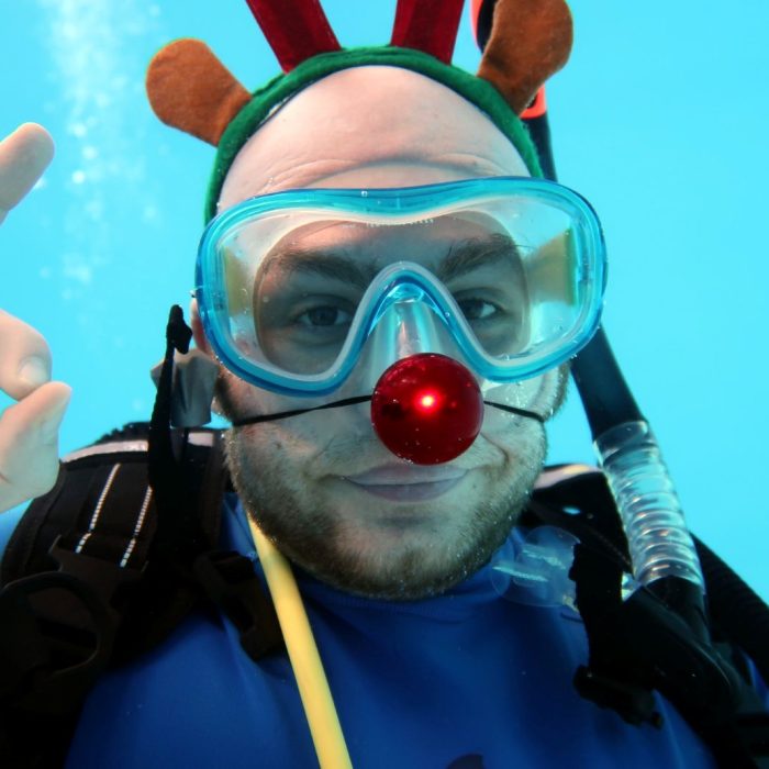 Scafandru cu masca si coarne de ren, oferind semnul OK sub apa, in cadrul evenimentului de Craciun organizat de Deep Zone Diving.