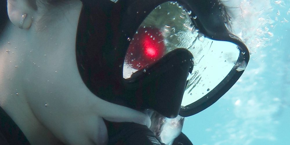 Prim-plan cu un scafandru care poarta masca de scufundare si caciula de Mos Craciun, in timpul unei sesiuni festive organizate de Deep Zone Diving.